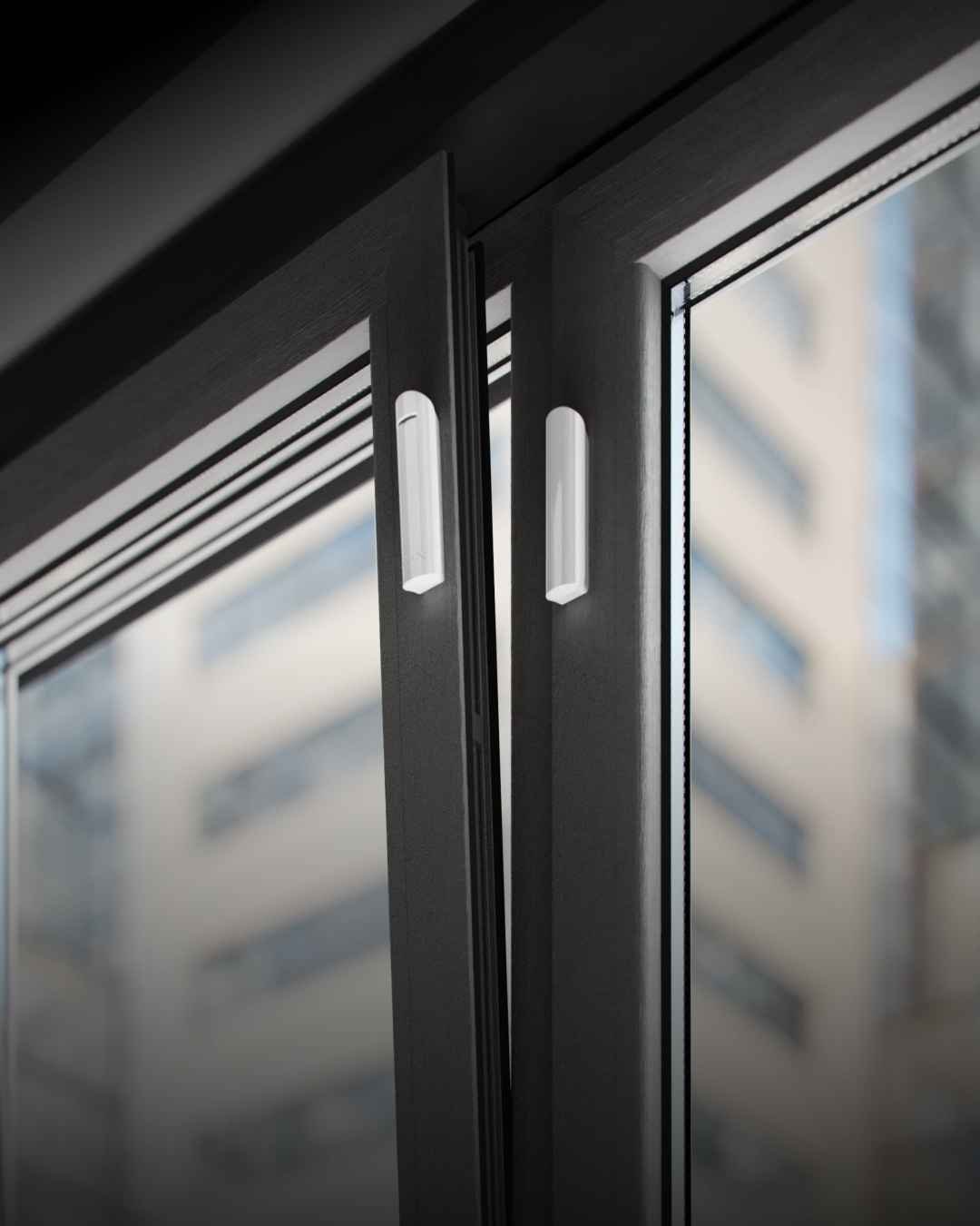 Wireless door and window alarm contact sensors fitted to aluminium joinery on an Auckland home