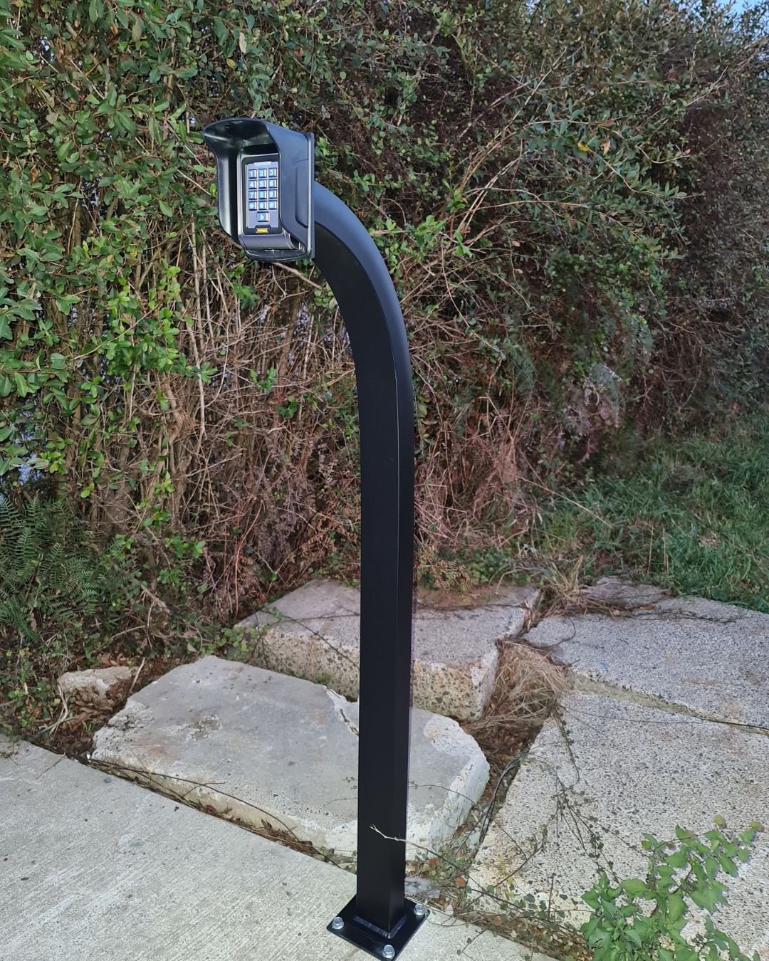 Black gooseneck pedestal post with gate intercom at a residential driveway in Silverdale, Auckland