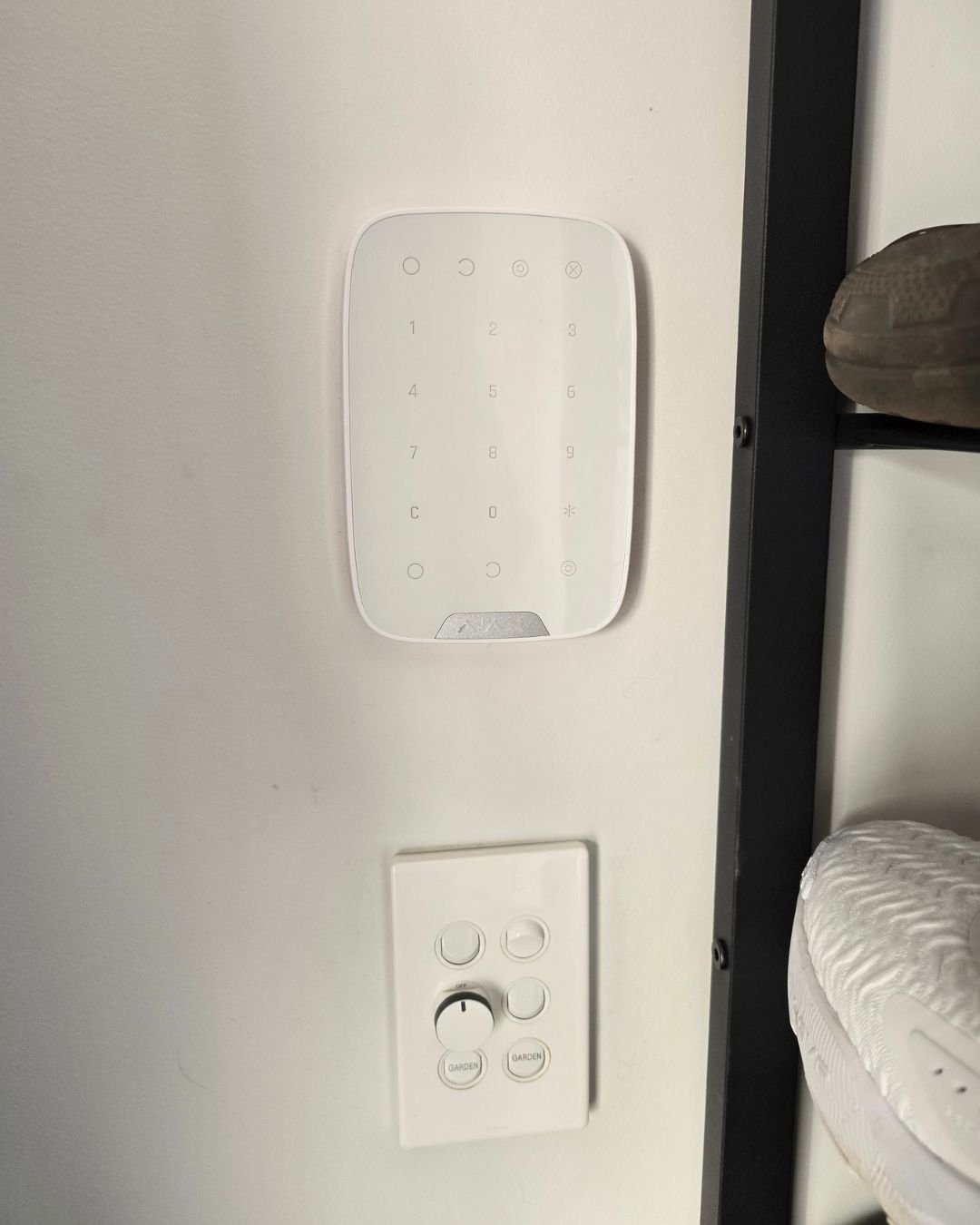 Indoor alarm system keypad mounted on a hallway wall in a residential home in Orewa, Auckland