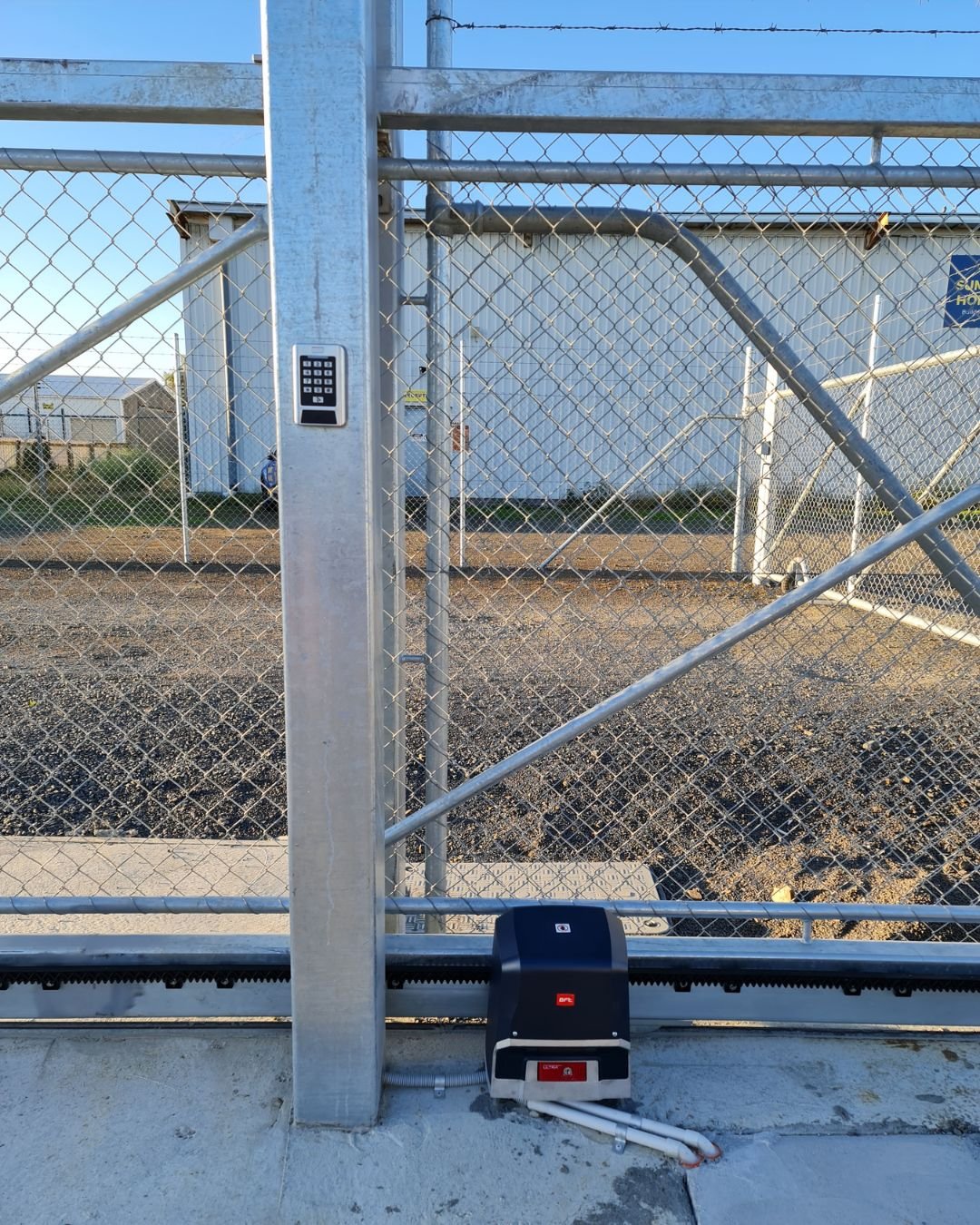 Sliding gate motor installed at a mesh security gate on a commercial yard in Auckland